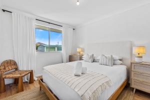 Una habitación blanca con una cama y una ventana en Harbour Mist Hideaway - Where Coast Meets Calm, en Ulladulla