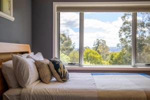 a bedroom with a bed with a large window at Bonnie Belle, Norwood in Kings Meadows