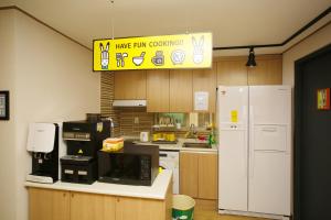 a kitchen with a microwave and a refrigerator at 24 Guesthouse KyungHee University in Seoul