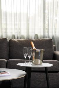 a table with two wine glasses and a bucket on it at Crest on Barkly Hotel in Melbourne