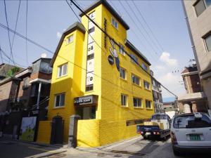 a yellow building on the side of a street at 24 Guesthouse KyungHee University in Seoul