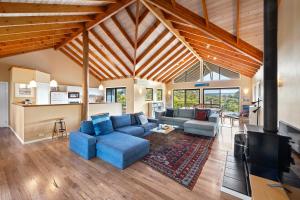 a living room with a blue couch and a fireplace at Yallingup Valley Views in Yallingup