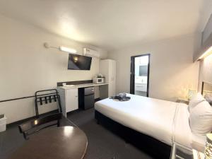 a hotel room with a large bed and a table at Motel St Arnaud in Saint Arnaud
