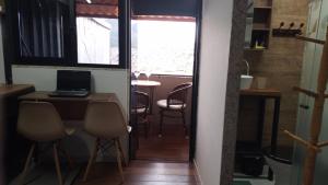 a room with a table with a laptop on a desk at Suite Bella Vista in Nova Friburgo