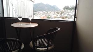 a table and two chairs in a room with a window at Suite Bella Vista in Nova Friburgo