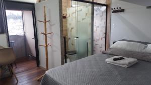 a bedroom with a bed with a glass door at Suite Bella Vista in Nova Friburgo