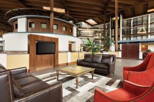 a lobby with chairs and a tv and a table at Radisson Hotel Lenexa Overland Park in Lenexa