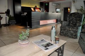 a coffee table with a bottle and a magazine on it at Hotel Bulevar in Paysandú