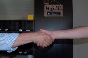 two people shaking their hands in a room at Hotel Bulevar in Paysandú