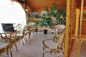ein Restaurant mit Tischen und Stühlen und einem Laptop darauf in der Unterkunft Viking Hotel in Gárdony