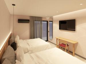 Una habitación de hotel con dos camas y un televisor. en Waves & Ko, en San Andrés