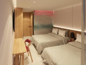 Una habitación de hotel con dos camas y una mesa y sillas. en Waves & Ko, en San Andrés