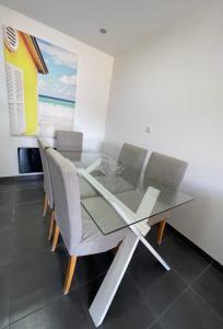 une salle à manger avec une table et des chaises en verre dans l'établissement Appartement 6 couchages, à Sainte-Maxime