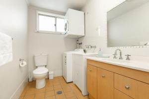 une salle de bain avec toilettes, lavabo et miroir dans l'établissement Lakeside Apartments 4, à Merimbula 17 autres photos