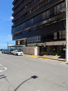 a large building with cars parked in front of it at Loft com vista da praia da Costa 612 in Vila Velha