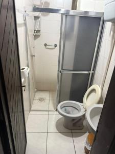 een kleine badkamer met toilet en douche bij Apartamento Dúplex in Cidreira