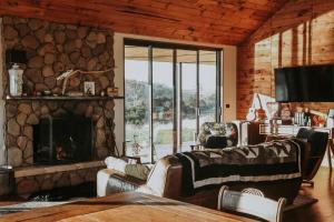 a living room with a fireplace and a stone wall at Swan River Sanctuary in Swansea