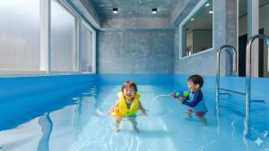 zwei Kinder spielen im Wasser im Pool in der Unterkunft Taean Blueisland Pool villa in Taean + 4 Fotos