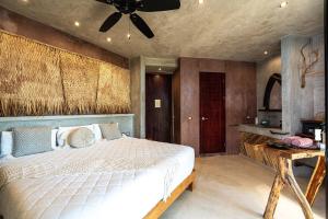 a bedroom with a bed and a ceiling fan at Xkeban Tulum Adults Only in Tulum
