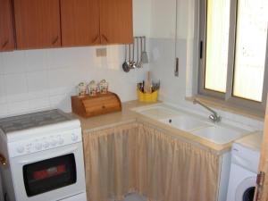 una cucina con lavandino e piano cottura di Casa Vacanze Serena ad Alcamo Marina