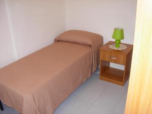 una camera con letto e comodino con lampada verde di Casa Vacanze Serena ad Alcamo Marina
