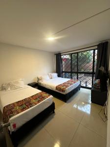 a hotel room with two beds and a large window at Bamuka Hostal in Bogotá