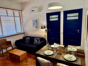 un soggiorno con porte blu, un tavolo e un divano di Ipanema Prudente Posto 9 a Rio de Janeiro