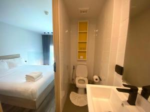 a small bathroom with a bed and a sink at utopia naihan in Phuket Town +5 photos