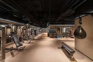a gym with a row of treadmills and machines at Flow and Co. Qingdao, Autograph Collection in Qingdao