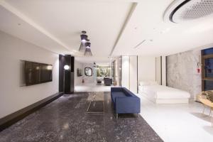 a living room with a blue couch and a tv at Stayrak Hotel in Seoul +42 photos