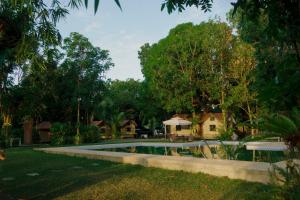 a swimming pool in a yard with houses and trees at Balai sa Bundok in Bolinao