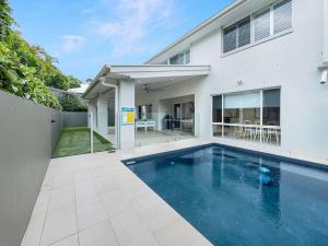 a swimming pool in the backyard of a house at Relaxed Luxury for Families by the Beach in Buddina +23 photos