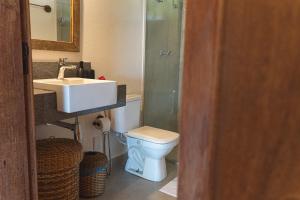 a bathroom with a toilet and a sink and a shower at Vila Katuara in Santa Cruz Cabrália +40 photos