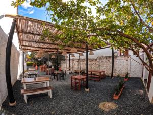 a patio with tables and chairs under a wooden pergola at Hostal casa de los sueños in Villa de Leyva