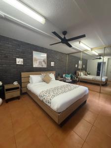 a bedroom with a bed and a ceiling fan at Pasir Penyu, Turtle Sands Modern Coastal Escape near Kellys Beach in Bargara