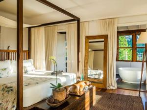 a bedroom with a large bed and a bath tub at Santa Teresa Hotel Rio de Janeiro - MGallery Collection in Rio de Janeiro