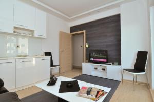 a living room with white furniture and a tv at ACO Apartment in Trebinje