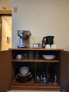 una mensola con macchinetta del caffè e piatti di Licensed Private Cozy Basement Suite Near Downtown Saskatoon a Saskatoon Altre 34 foto