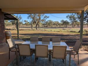 une table et des chaises sur une terrasse avec un champ dans l'établissement Willa Villa Bush Retreat - Gol Gol, à Gol Gol