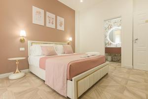 a bedroom with a large bed with a pink blanket at boutique teatro b&b in Foggia