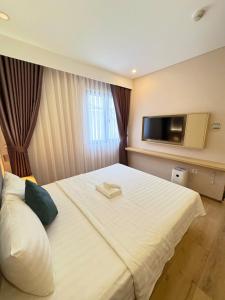 a hotel room with a bed with a television on the wall at ELONG me hotel in Ho Chi Minh City +5 photos