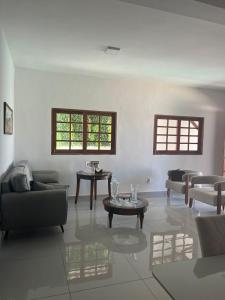 un soggiorno con divani, tavoli e finestre di Casa barra nova M e Az a Marechal Deodoro