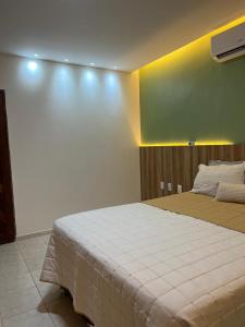 una camera da letto con un letto e una parete verde di Casa barra nova M e Az a Marechal Deodoro