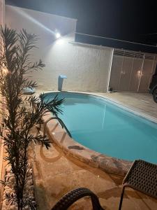 una grande piscina con un tavolo e una pianta di Casa barra nova M e Az a Marechal Deodoro