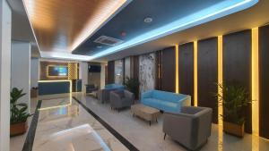 a lobby with a waiting room with blue chairs at Front One Luxe Hotel Solo in Solo