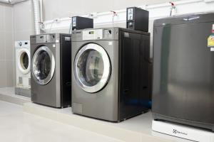 a row of washing machines in a laundry room at UTD8 Hotel and Residence in Bangkok
