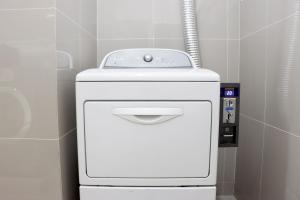 a white toilet in a bathroom with a pipe at UTD8 Hotel and Residence in Bangkok