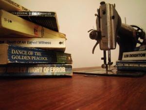 a pile of books sitting on a table next to a machine at Hostel Raymundo in Évora