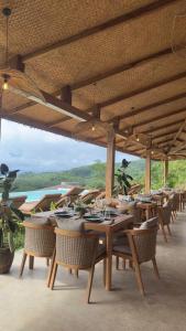 - un restaurant avec des tables et des chaises en bois offrant une vue dans l'établissement Atalaya Resort El Nido, à El Nido