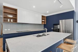 a kitchen with blue walls and a white counter top at Riverside Retreat - Waterfront - Hindmarsh Island - Linen Included in Hindmarsh Island +32 photos